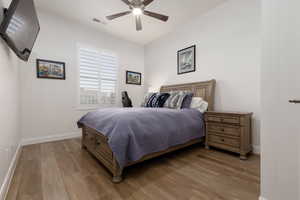 Bedroom featuring ceiling fan and hardwood / wood-style flooring