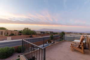 Patio terrace at dusk with a balcony and a mountain view