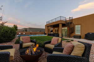 Patio terrace at dusk featuring a fire pit, a grill, and a fenced in pool