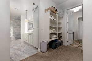 Corridor featuring light colored carpet and sink