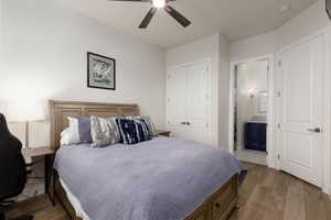 Bedroom featuring dark wood-type flooring, ceiling fan, a closet, and ensuite bathroom