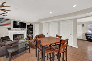 Dining area featuring a tiled fireplace and light wood-type flooring