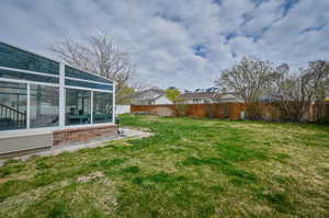 View of yard featuring a sunroom