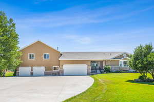 View of front of property with a garage and a front lawn