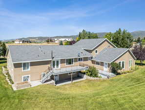 Back of property with a yard, a patio, and a mountain view