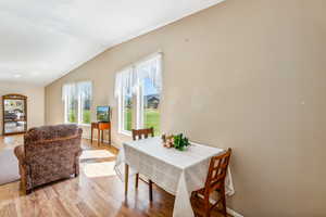 Dining room with lofted ceiling and light hardwood / wood-style floors