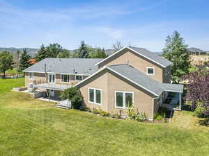 Back of property featuring a lawn and a patio area