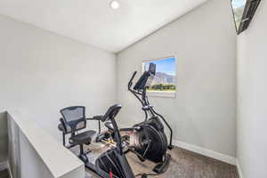 Exercise area with lofted ceiling and carpet floors