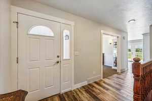 Foyer featuring dark wood-type flooring and a textured ceiling