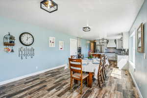 Dining space with dark wood-type flooring and sink