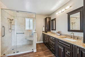 Bathroom with an enclosed shower, hardwood / wood-style flooring, and vanity