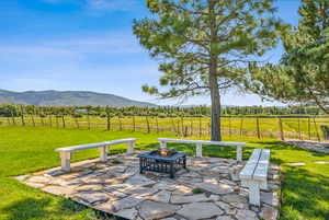 View of patio featuring an outdoor fire pit, a mountain view, and a rural view