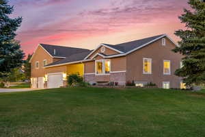 View of front of home featuring a garage and a yard