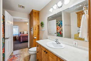 Bathroom with tile patterned flooring, toilet, ceiling fan, and vanity