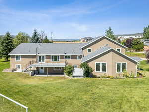 Rear view of house featuring a patio area and a yard