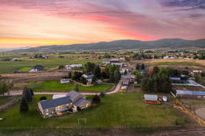 Aerial view at dusk featuring a mountain view and a rural view