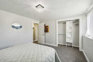 Bedroom with dark carpet and a closet