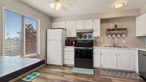 Kitchen featuring white cabinets, stainless steel appliances, light hardwood / wood-style floors, sink, and ceiling fan