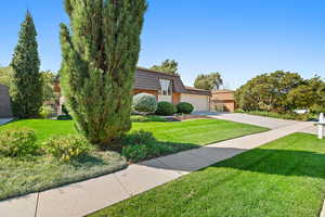 View of front of property featuring a garage and a front lawn