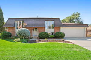 View of front of home featuring a garage and a front lawn