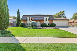 View of front of property featuring a front yard and a garage