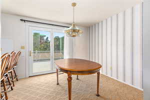 Dining space featuring an inviting chandelier and light colored carpet