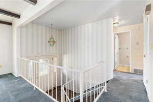 Corridor featuring beam ceiling and carpet floors