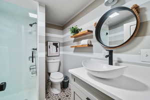 Bathroom featuring vanity, toilet, ornamental molding, and walk in shower