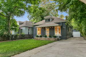 Bungalow-style house featuring a front yard and a garage