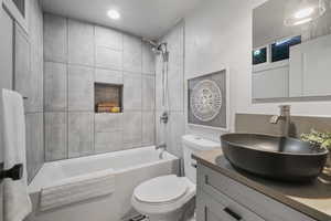 Full bathroom with vanity, toilet, and tiled shower / bath combo