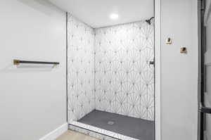 Bathroom featuring hardwood / wood-style floors and a tile shower