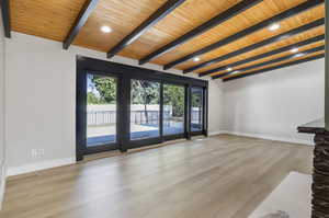 Unfurnished room with beamed ceiling, wooden ceiling, and light hardwood / wood-style floors