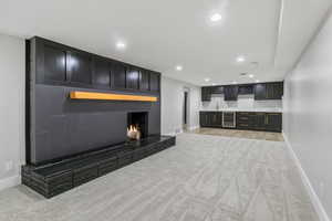 Living room featuring beverage cooler, sink, and light colored carpet