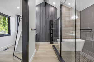 Bathroom featuring hardwood / wood-style flooring and shower with separate bathtub