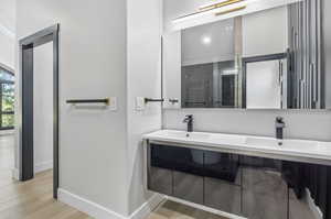 Bathroom featuring hardwood / wood-style floors, a shower with door, and vanity