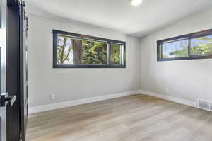 Empty room with light hardwood / wood-style floors