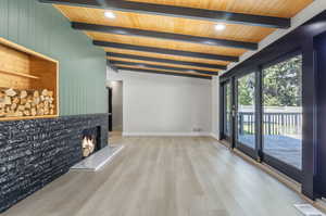 Unfurnished living room with lofted ceiling with beams and light hardwood / wood-style flooring