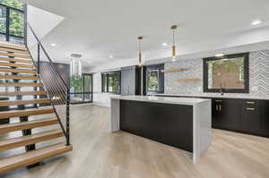 Kitchen featuring a healthy amount of sunlight, light hardwood / wood-style flooring, and decorative backsplash