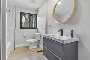 Bathroom featuring toilet, hardwood / wood-style flooring, and vanity