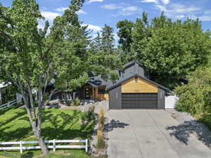 View of front of property featuring a garage and a front lawn