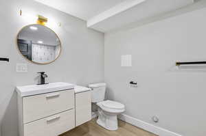 Bathroom with hardwood / wood-style floors, toilet, and vanity