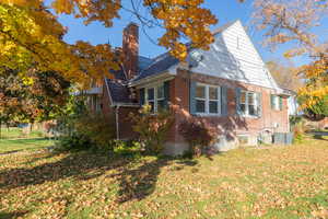 View of side of property featuring central air condition unit and a lawn