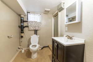 Bathroom featuring vanity, a textured ceiling, and toilet