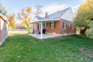 Back of property with a lawn and a patio area