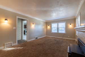 Unfurnished living room with carpet flooring, a textured ceiling, and a high end fireplace