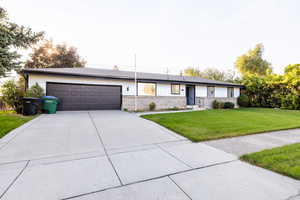 Ranch-style house featuring a front yard and a garage