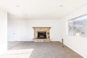 Unfurnished living room with carpet floors and a fireplace