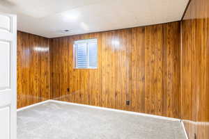 Empty room with wood walls and carpet floors