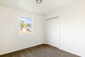 Unfurnished bedroom with carpet and a closet