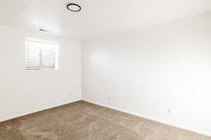 Carpeted spare room featuring a textured ceiling